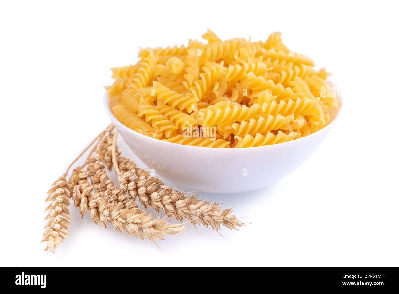 Pâtes et épillets de blé isolés sur fond blanc, bannière, en-tête, gabarit avec espace de copie. Pâtes alimentaires crues fusilli, ingrédient pour la cuisson, traditionnel i Banque D'Images