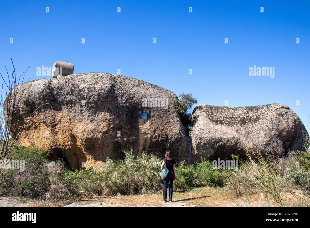 Turista observando algunas de las rocas de granito en la Reserva Natural de Los Barruecos, Malpartida de Cáceres, España Banque D'Images