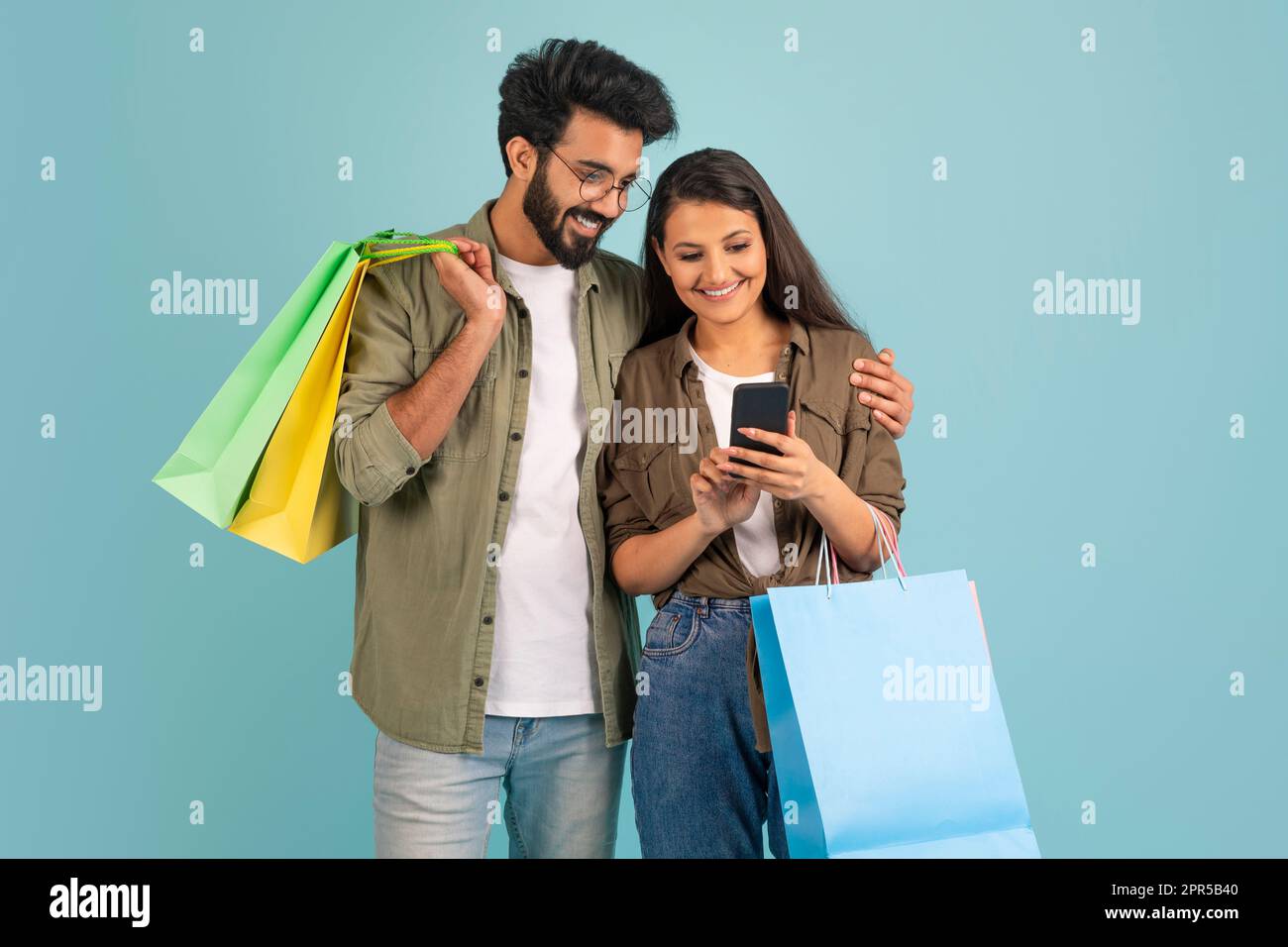 Amoureux du couple indien en utilisant l'application mobile de shopping agréable, l'espace de copie Banque D'Images
