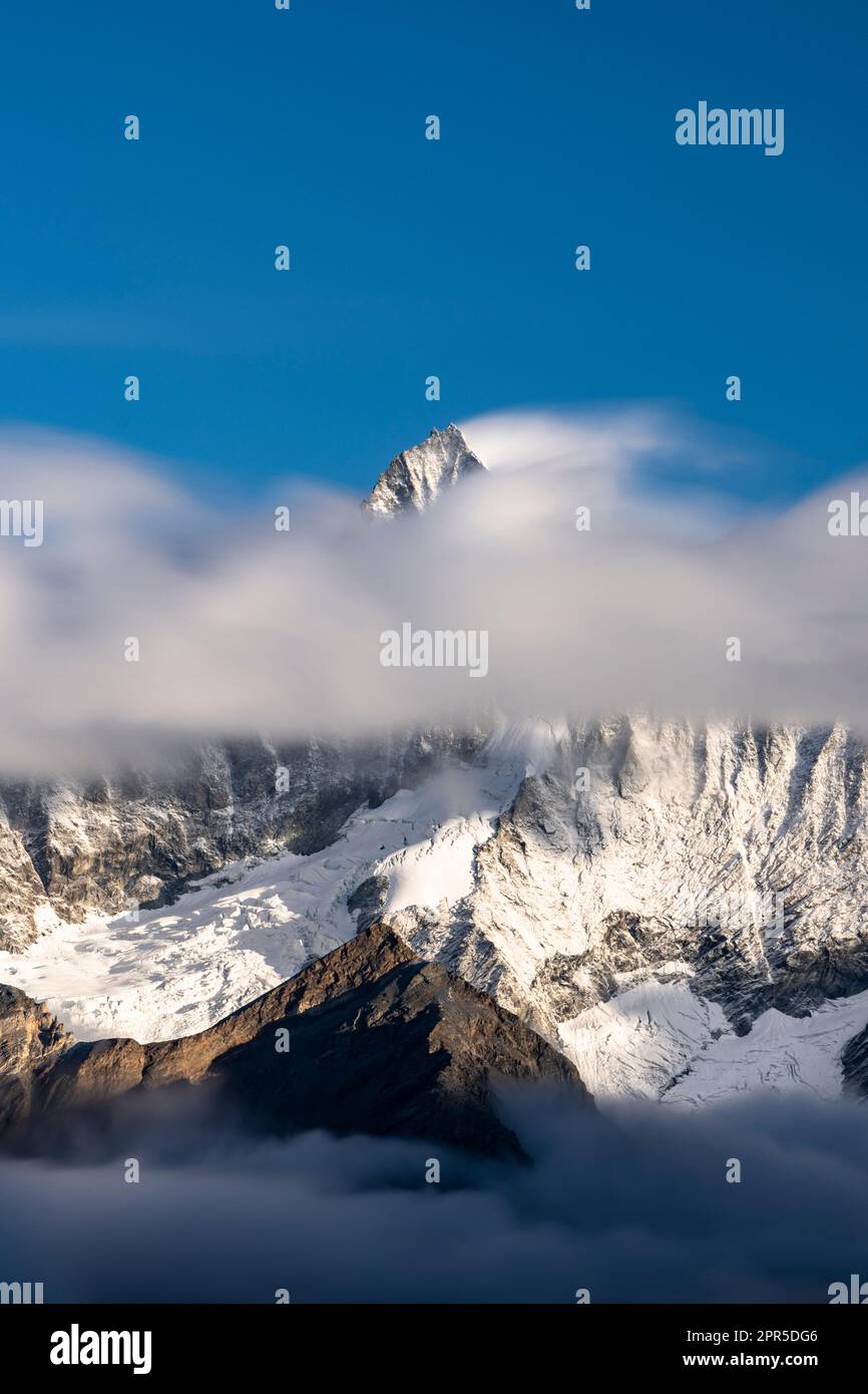 Ciel clair au-dessus du pic neigeux de Weisshorn dans la brume à l'aube, Zermatt, canton du Valais, Suisse Banque D'Images