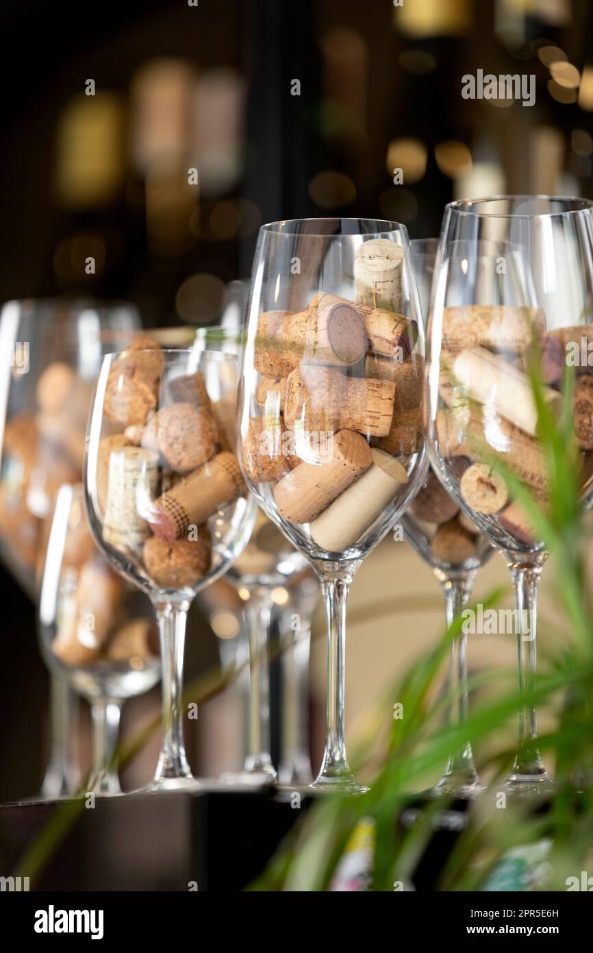 Une rangée de verres à vin sur un bar avec des bouchons de bouteilles de vin à l'intérieur. Banque D'Images