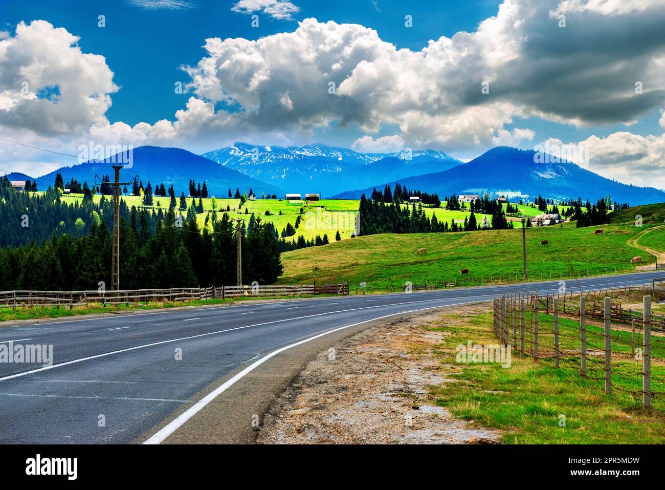L'autoroute est dans les hautes montagnes avec les sommets enneigés. Banque D'Images