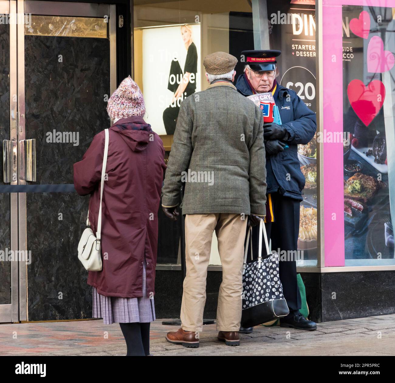 Couple parlant à un membre de l'Armée du Salut, High Street, Lincoln City 2023 Banque D'Images