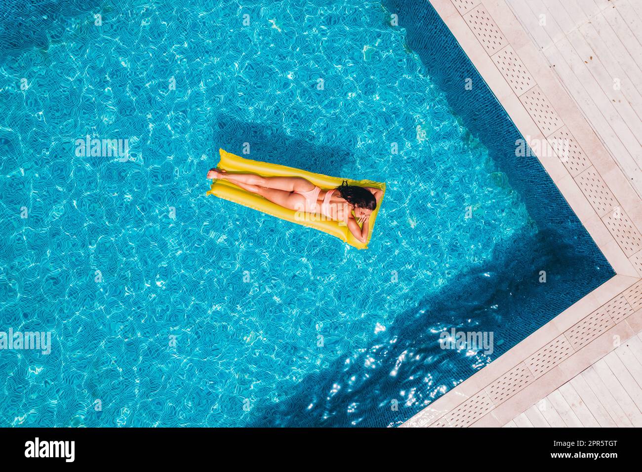 Fille en maillot de bain qui bronzent dans une piscine Banque D'Images