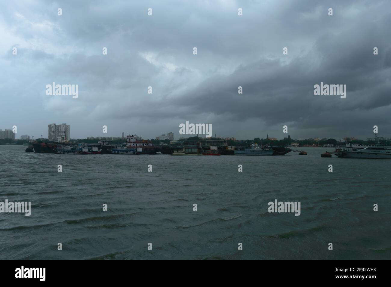 Ferry Bateaux flottant au-dessus de la rivière Ganges à une distance lors d'une journée spectaculaire et nuageux. Magnifique paysage vue horizon de Babu Ghat. Kolkata Bengale occidental Inde Asie du Sud 19 juin 2022 Banque D'Images