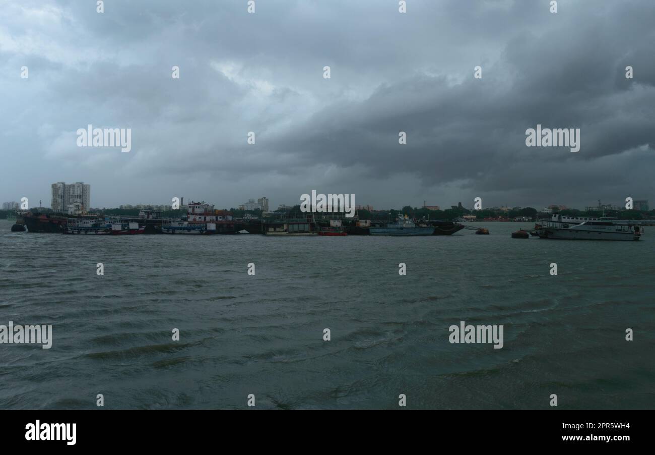 Ferry Bateaux flottant au-dessus de la rivière Ganges à une distance lors d'une journée spectaculaire et nuageux. Magnifique paysage vue horizon de Babu Ghat. Kolkata Bengale occidental Inde Asie du Sud 19 juin 2022 Banque D'Images