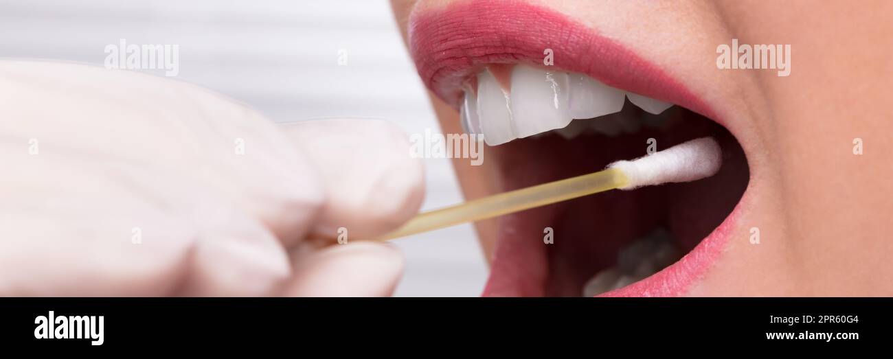 En tenant la main du dentiste de test de salive bouche de femme Banque D'Images