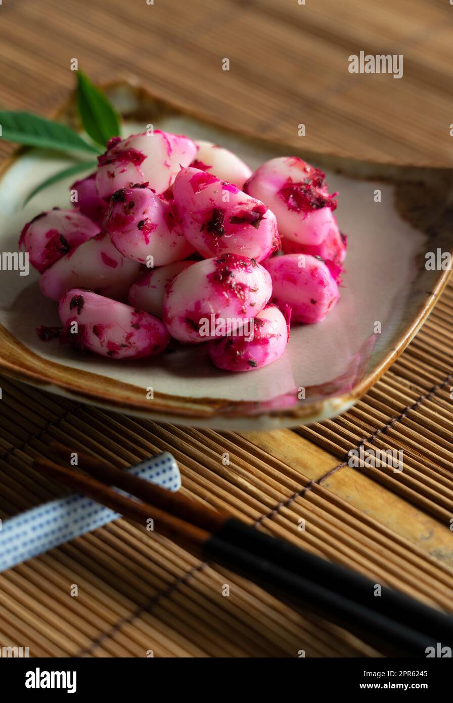 De l'ail de bonito de shiso mariné servi sur une assiette placée sur un tapis de pain en bambou. Banque D'Images