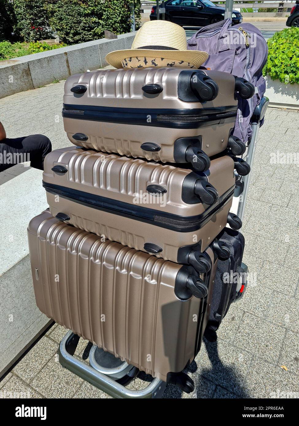 Valises sur un porte-bagages portant un chapeau de soleil à l'aéroport Banque D'Images