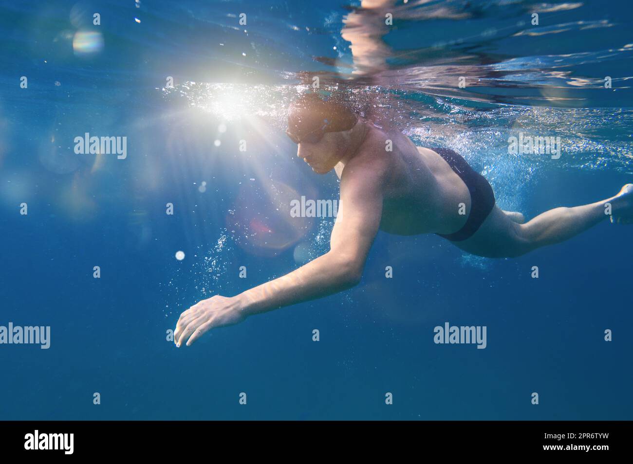 L'homme sportif nage rapidement dans la mer Banque D'Images
