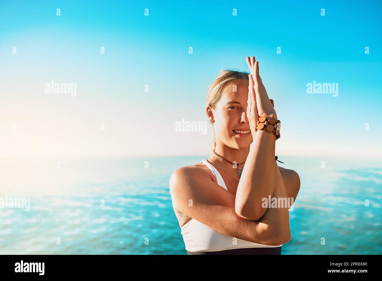Assurez-vous que vos pensées sont positives et puissantes. Photo d'une jeune femme sportive pratiquant le yoga sur la plage. Banque D'Images