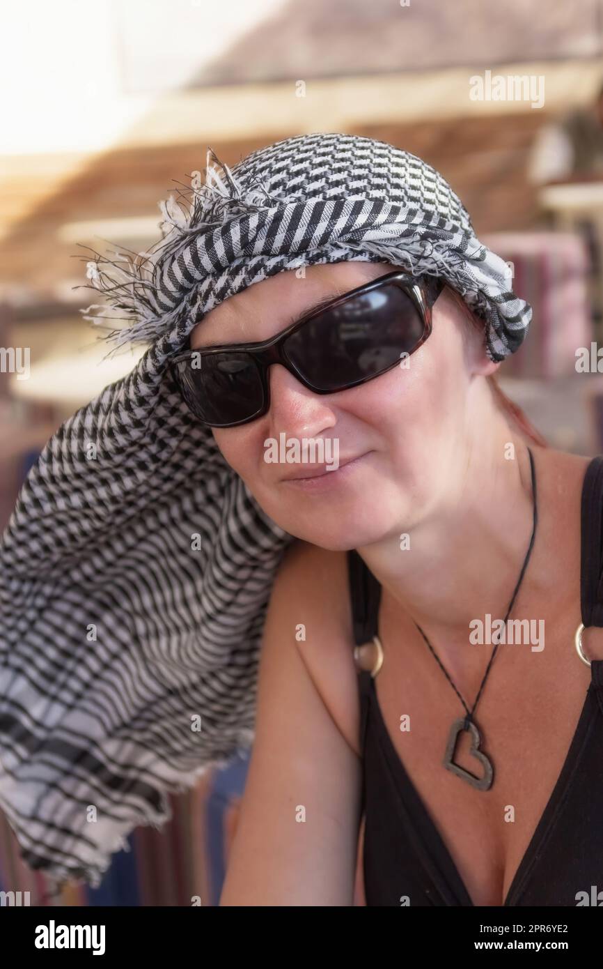 Portrait d'une femme touristique vêtue d'un foulard arafatka et de lunettes de soleil. Banque D'Images