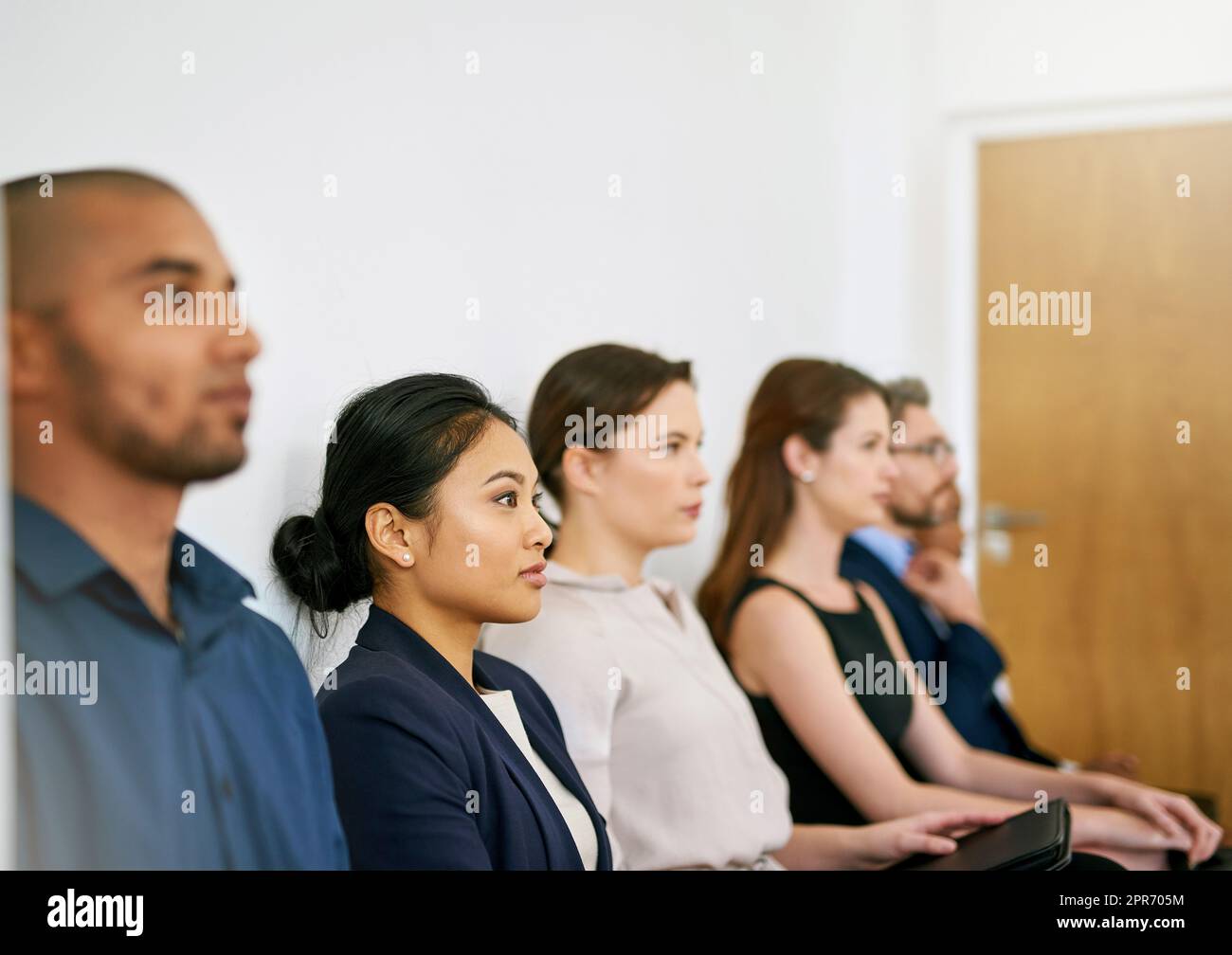 Prêt à impressionner. Photo d'un groupe d'hommes d'affaires assis en file d'attente en attendant d'être interviewés. Banque D'Images