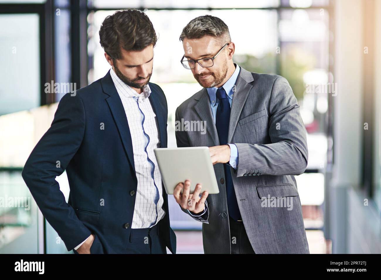 Exploiter de nouveaux marchés pour développer leur activité. Photo rognée de deux hommes d'affaires travaillant ensemble sur une tablette numérique dans un bureau. Banque D'Images