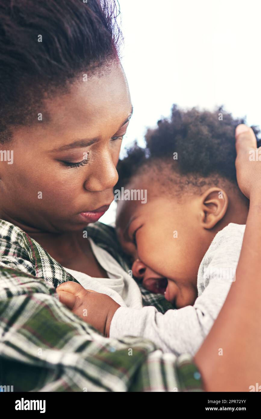 Je n'aime pas quand c'est triste. Photo courte d'une jeune mère qui berce son bébé garçon. Banque D'Images