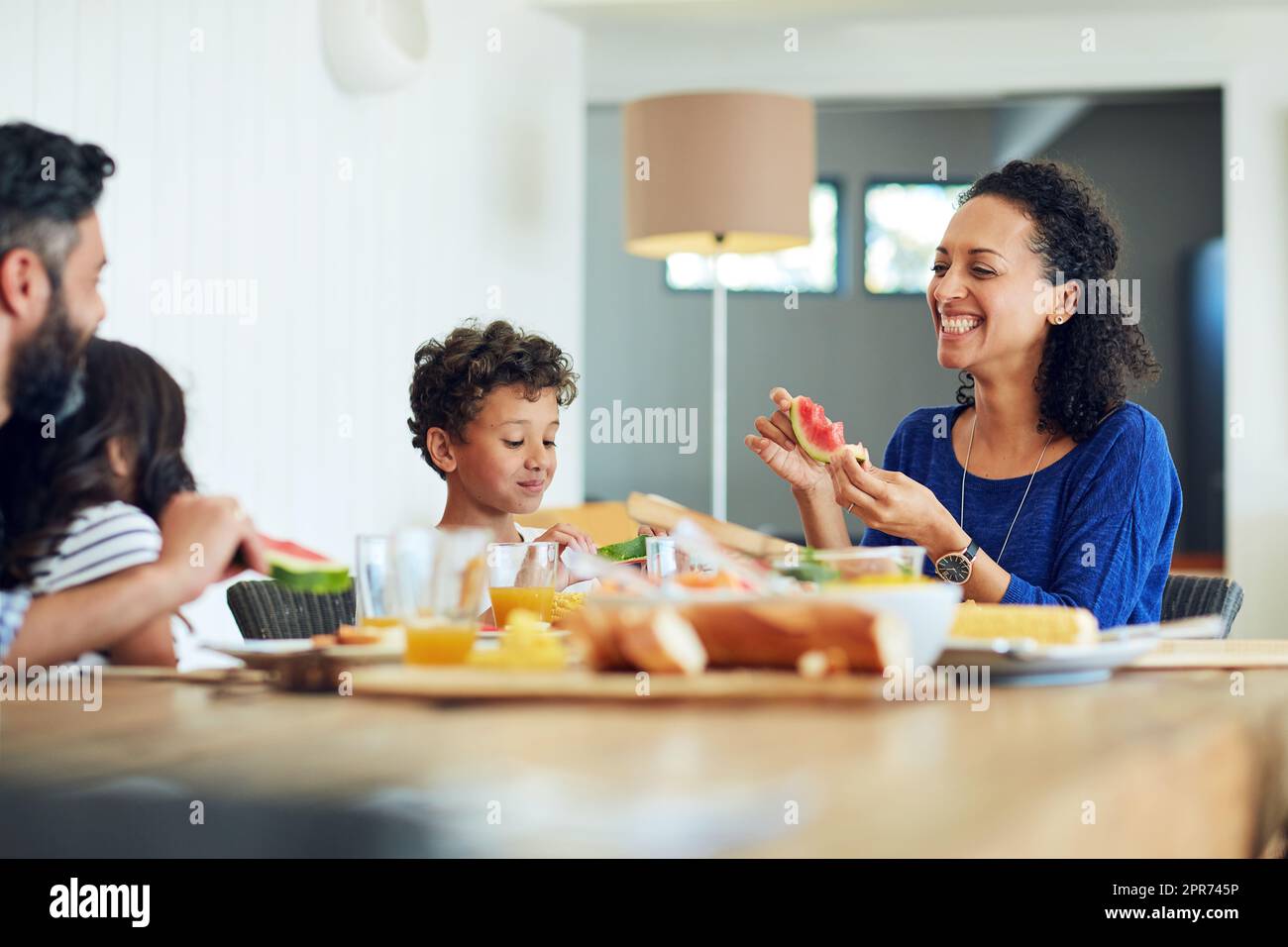 Manger sainement et se sentir heureux. Photo d'une famille heureuse réunie autour de leur table pour un repas. Banque D'Images