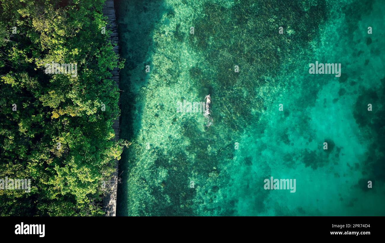 L'endroit idéal pour nager. Photo en grand angle d'un homme méconnaissable nageant autour des belles îles de Raja Ampat. Banque D'Images