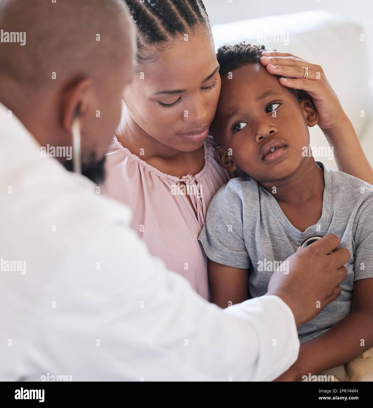 Un pédiatre afro-américain examine un garçon malade avec un stéthoscope lors d'une visite avec une maman. Médecin vérifiant les poumons cardiaques pendant le contrôle à l'hôpital. Garçon malade ou triste recevant des soins médicaux Banque D'Images