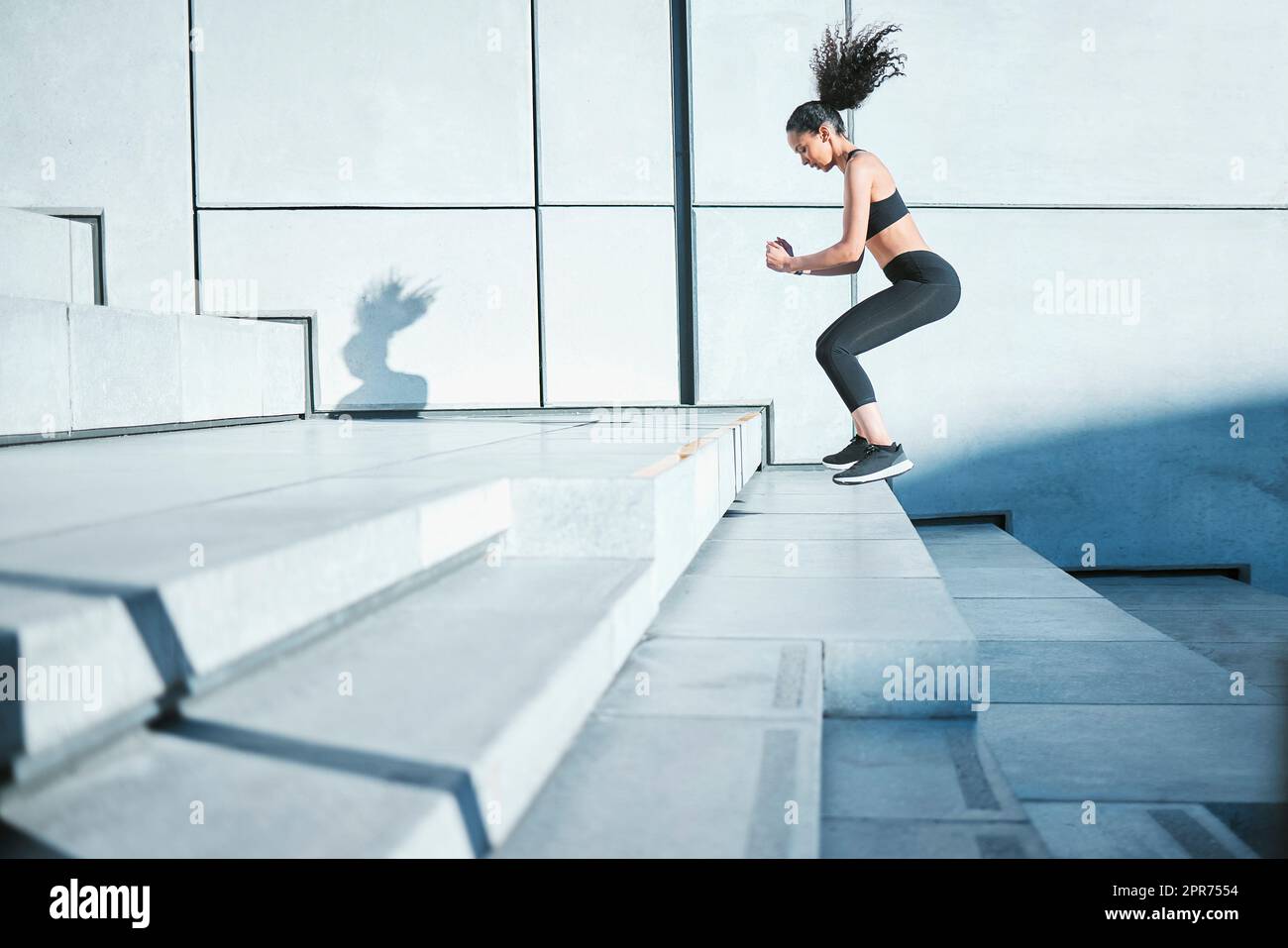En faisant un pas à la fois. Photo en longueur d'une jeune athlète féminine attirante s'exerçant à l'extérieur de la ville. Banque D'Images