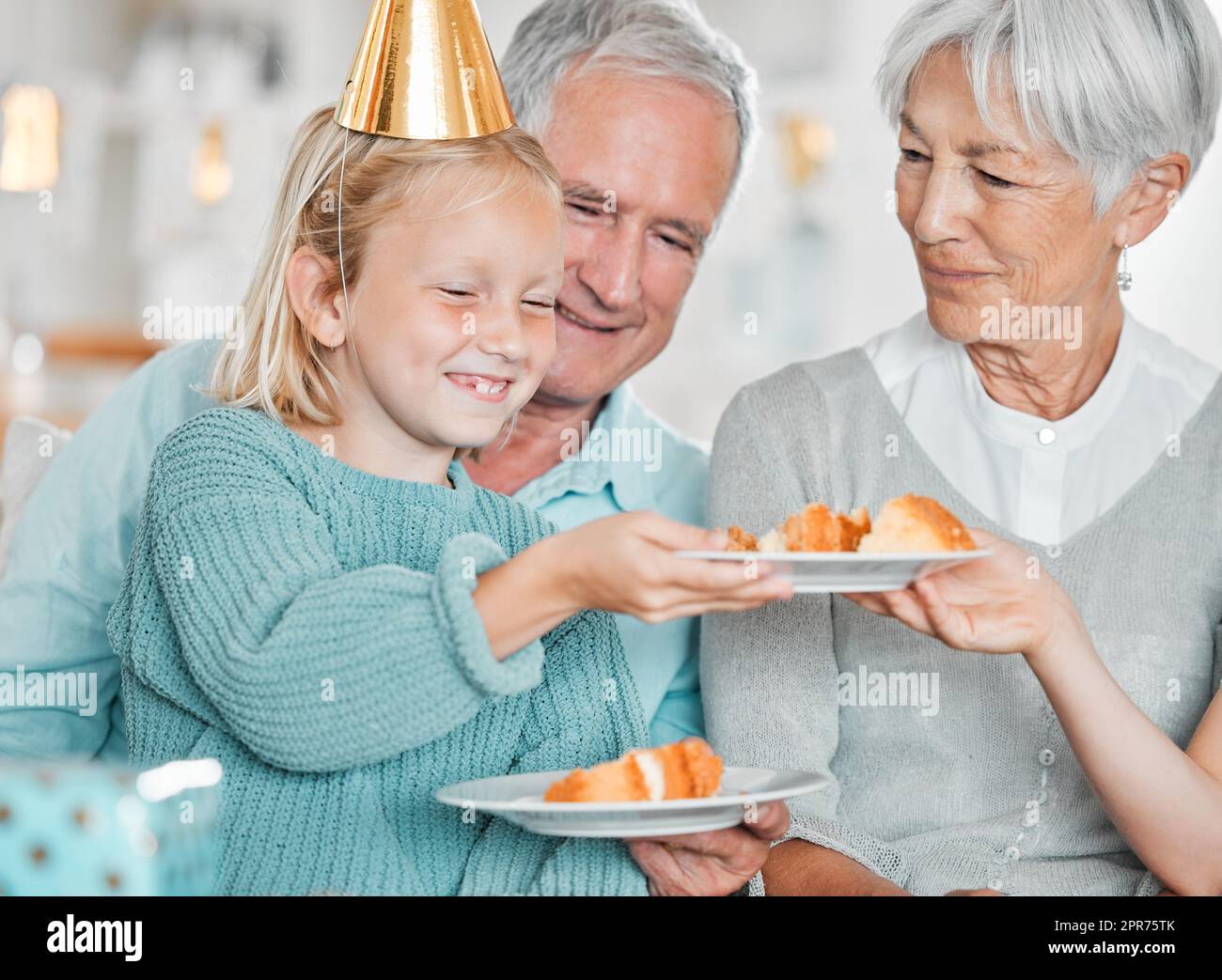 Chaque bodys se fait un gâteau. Photo courte d'une adorable petite fille célébrant un anniversaire à la maison avec ses grands-parents. Banque D'Images