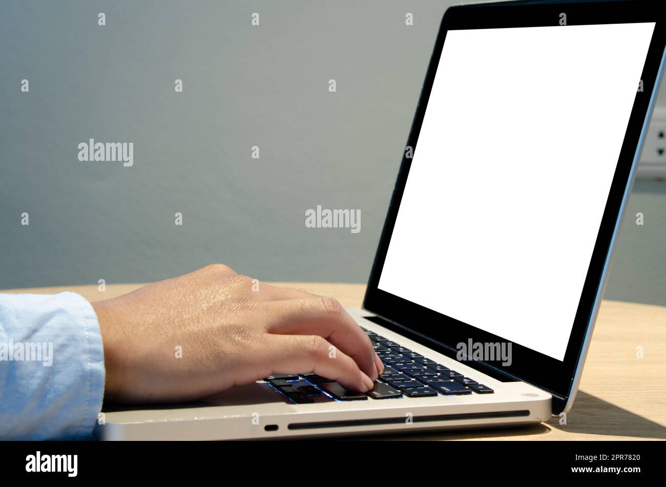 homme main utilisant le clavier ordinateur portable maquette écran vierge sur le bureau. Banque D'Images