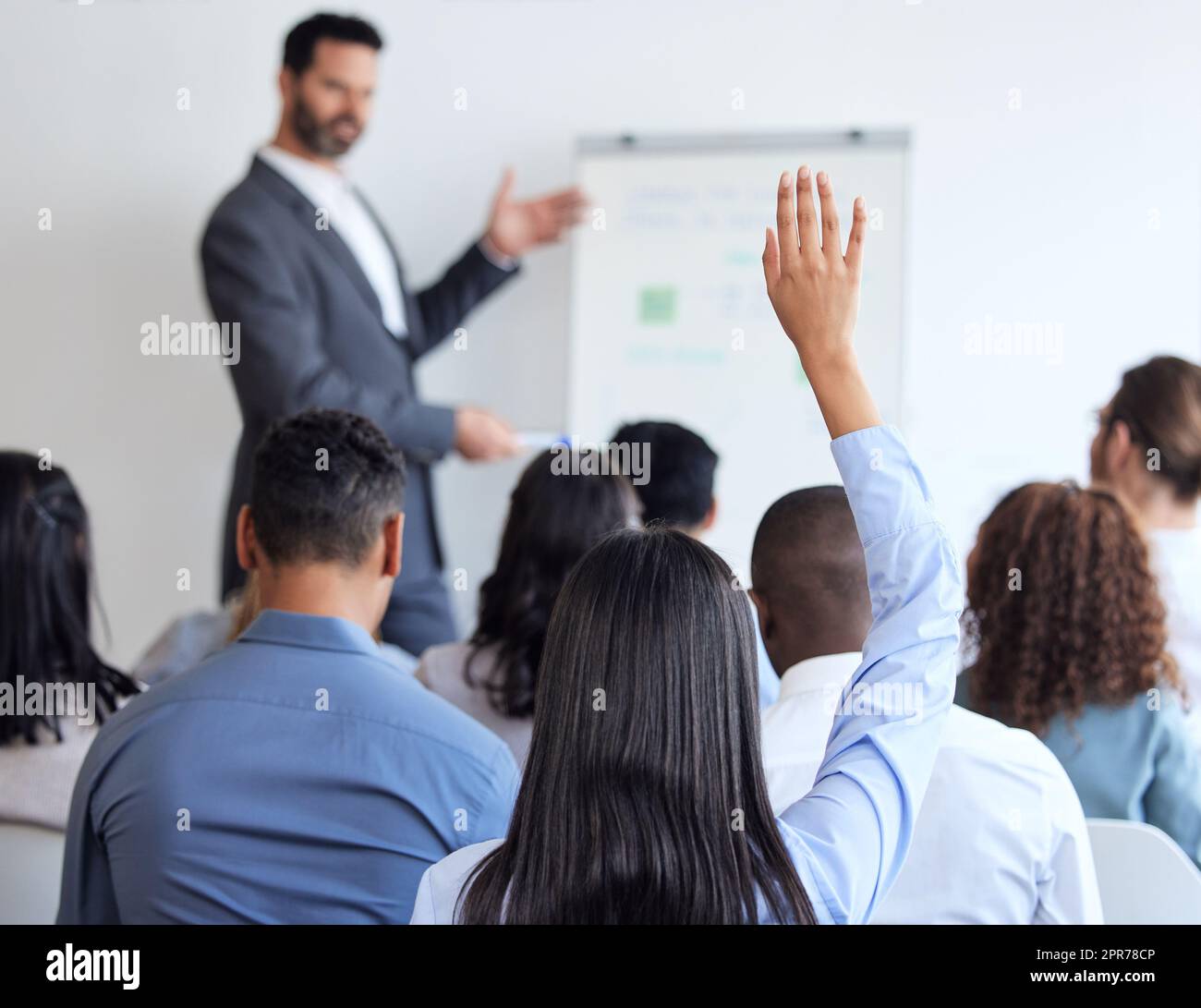 J'ai une question. Photo d'une femme d'affaires inreconnaissable assise avec sa main levée lors d'un séminaire dans la salle de conférence. Banque D'Images