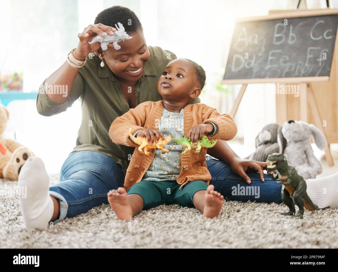 Quel son un dinosaure fait. Une mère jouant avec sa petite fille. Banque D'Images