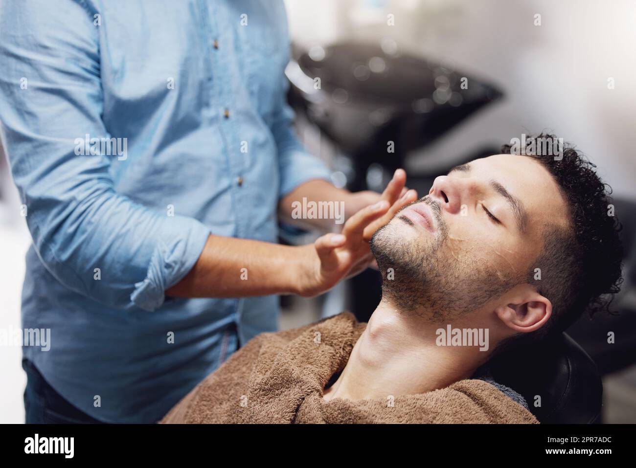 HES prêt à se faire dorloter. Un jeune homme charmant qui se prépare par un barbier. Banque D'Images