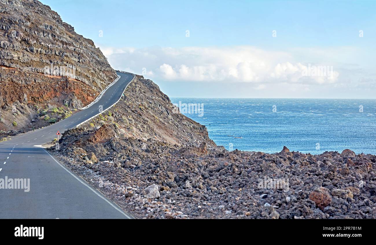 La Palma Island route de montagne pour un trajet jusqu'au sommet de la falaise sur une route sinueuse au bord de l'océan. Vue sur la côte en Espagne itinéraire côtier courbe avec ciel bleu nuageux et mer sur fond. Banque D'Images