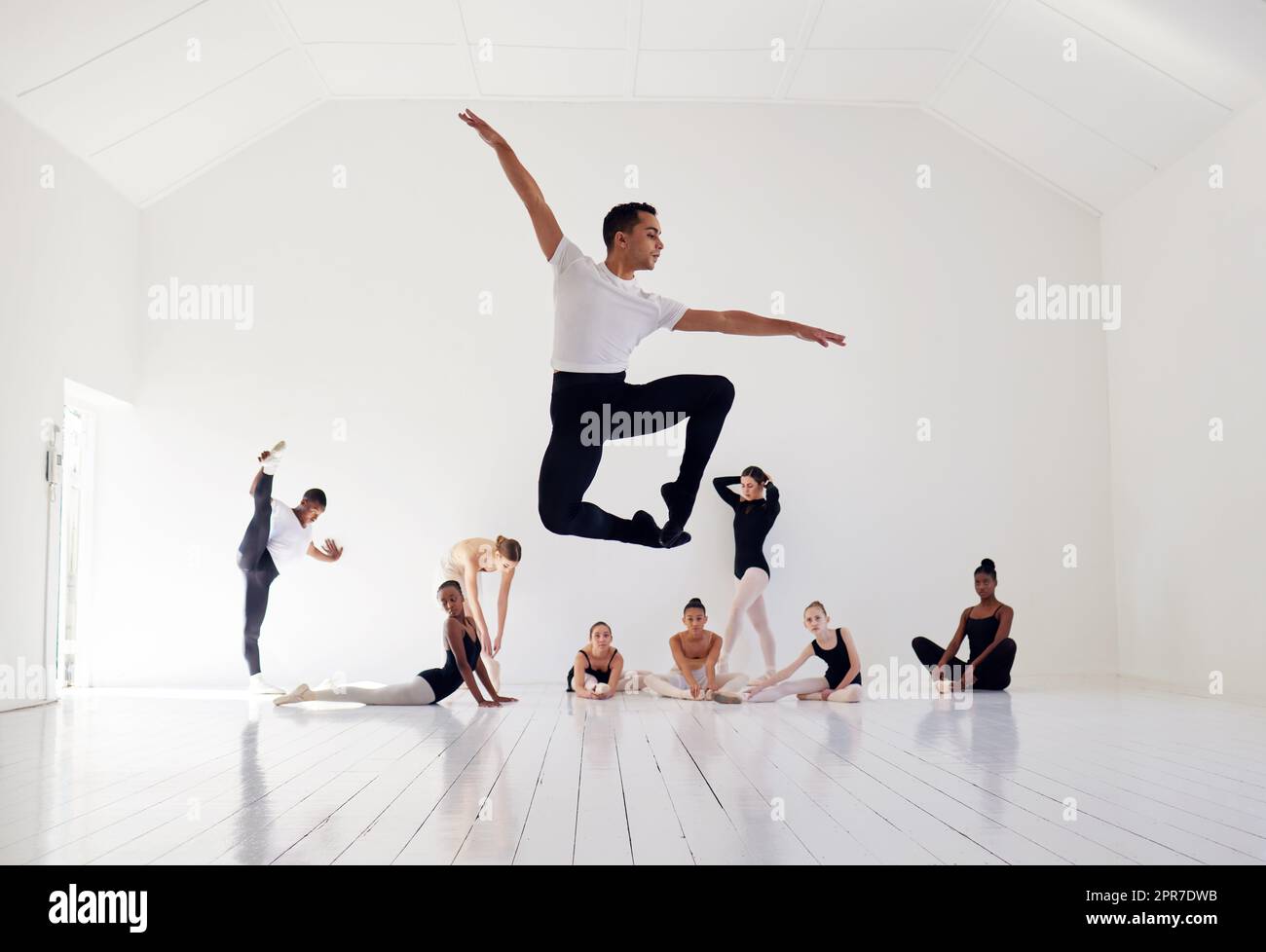 La danse est votre pouls, votre battement de coeur. Un groupe de danseurs de ballet pratiquant une routine dans un studio de danse. Banque D'Images