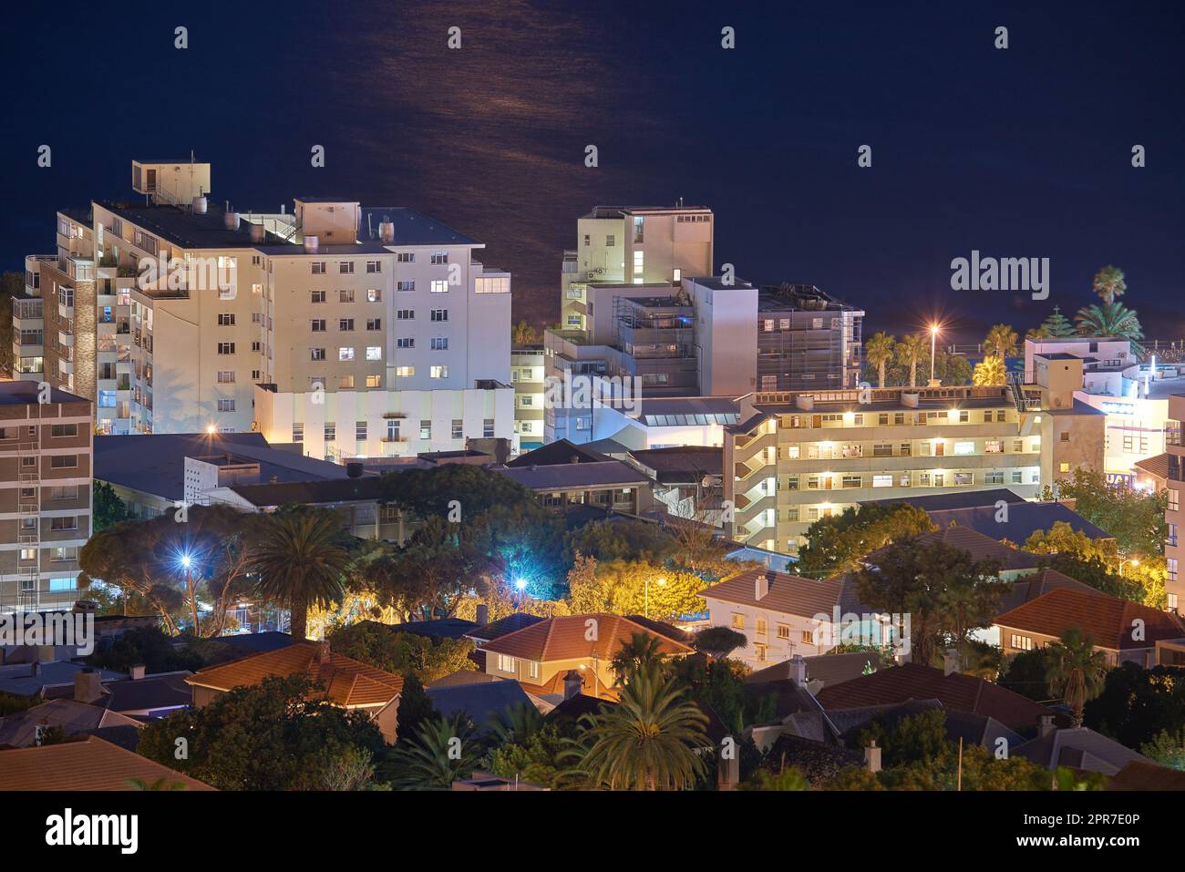 Vue nocturne sur les bâtiments de la ville avec éclairage électrique, infrastructure et fond de mer ou d'océan à l'étranger destination de voyage. Cape Town, centre-ville d'Afrique du Sud et architecture urbaine Banque D'Images