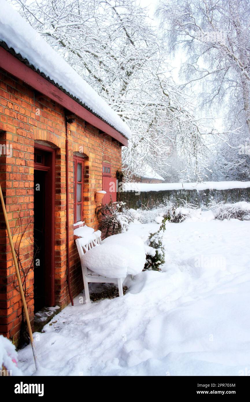 Vieille maison calme dans le paysage de neige et le jardin gelé. Un cottage en brique rouge en Europe avec une épaisse verglas blanc cour couverte en hiver avec espace de copie. Magnifique pays magique de neige en Scandinavie Banque D'Images