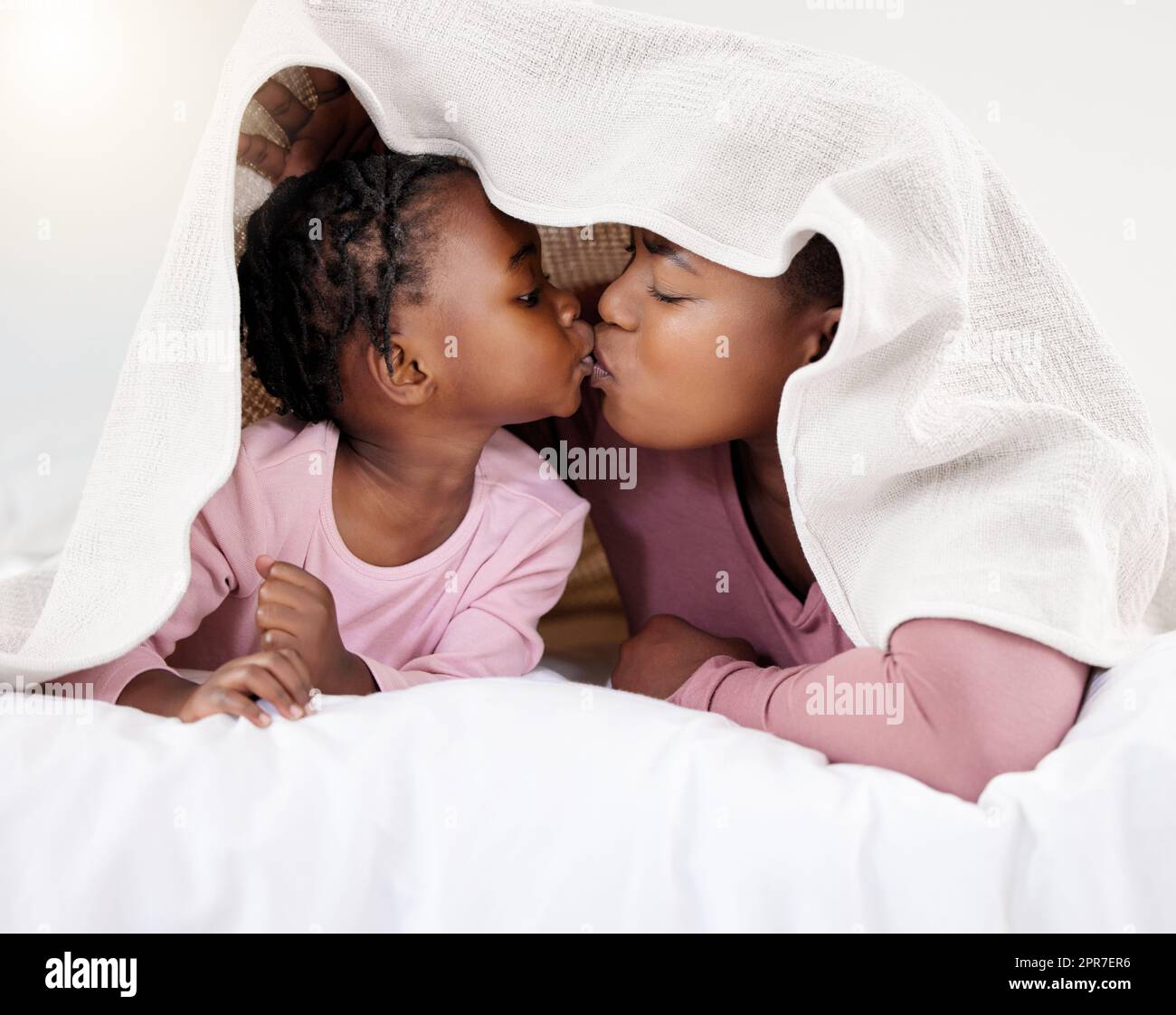 Merci Sweet girl. Photo d'une belle jeune femme qui se joint à sa fille au lit à la maison. Banque D'Images