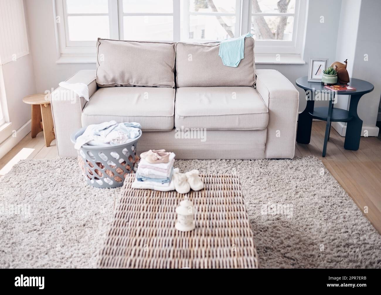 Vous ne pouvez jamais terminer une tâche avec des enfants dans la maison. Prise de linge dans un salon vide pendant la journée. Banque D'Images