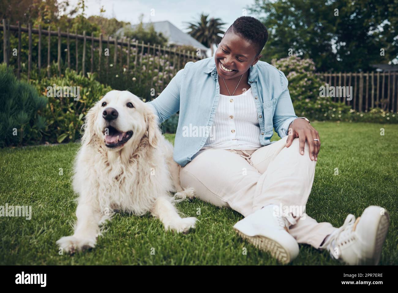 Avec mon âme est pleine. Photo d'une jeune femme attirante qui pète son chien dans le jardin. Banque D'Images