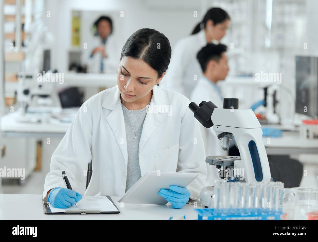 Shes dans la zone. Photo d'une jeune femme qui prend des notes dans son laboratoire. Banque D'Images