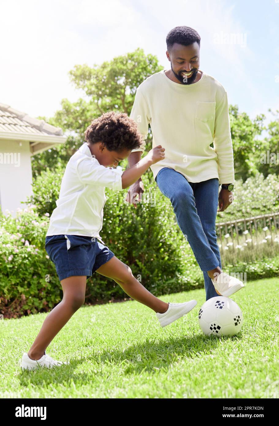 HES va s'attaquer à Dad pour le ballon. Un père et un fils jouant au football ensemble en plein air. Banque D'Images