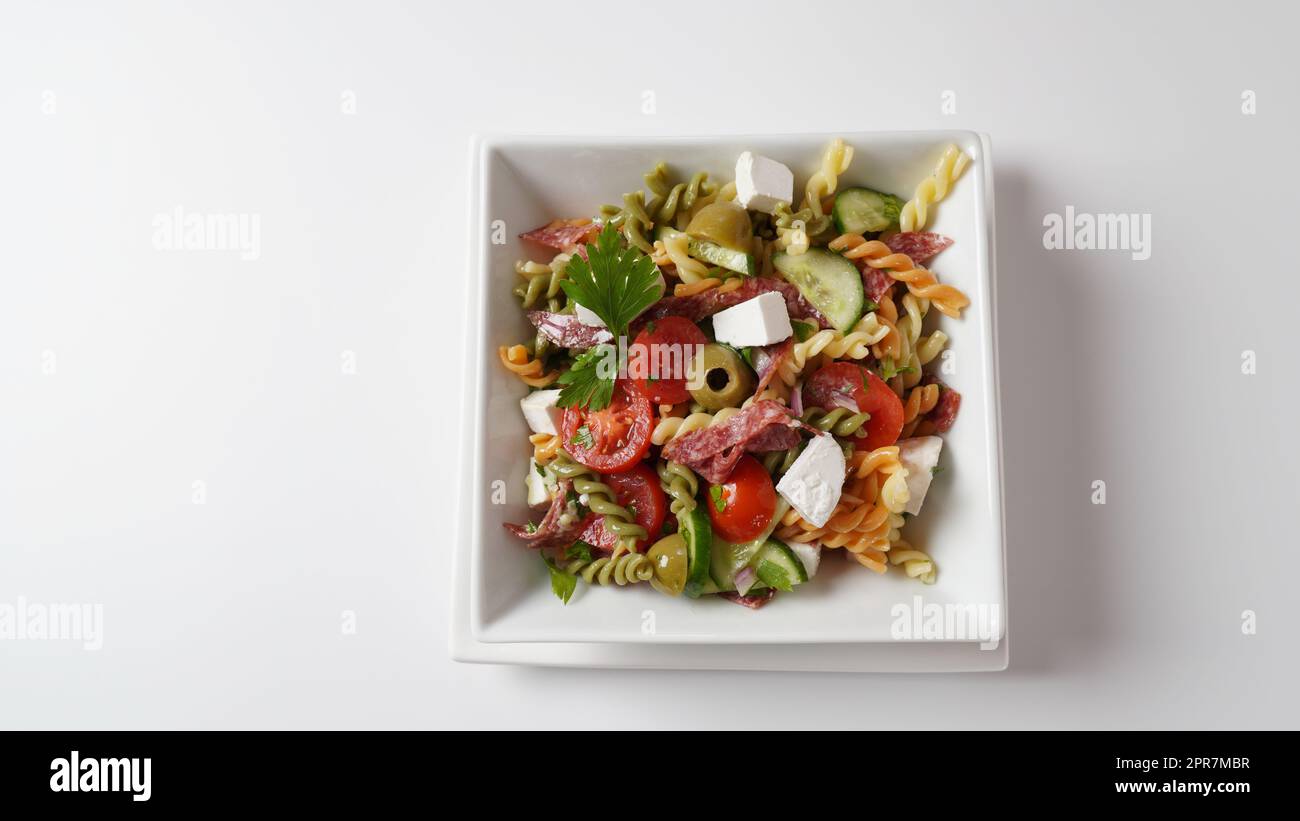 Salade de pâtes italiennes concombres, tomates cerises, olives, oignons rouges, salami, Fromage feta et rotini Banque D'Images