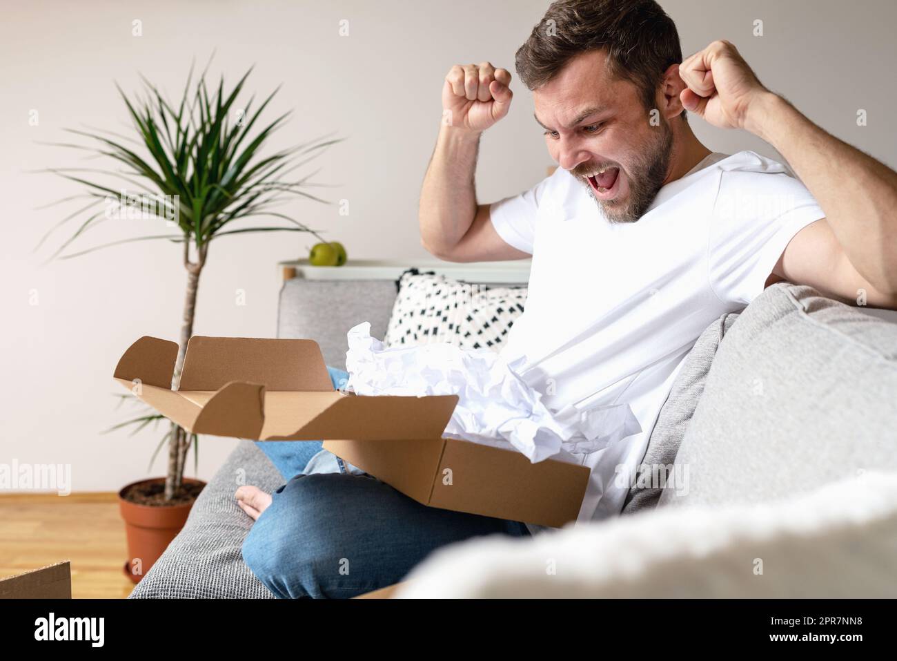 L'homme se réjouit du colis reçu avec sa commande Internet. Banque D'Images
