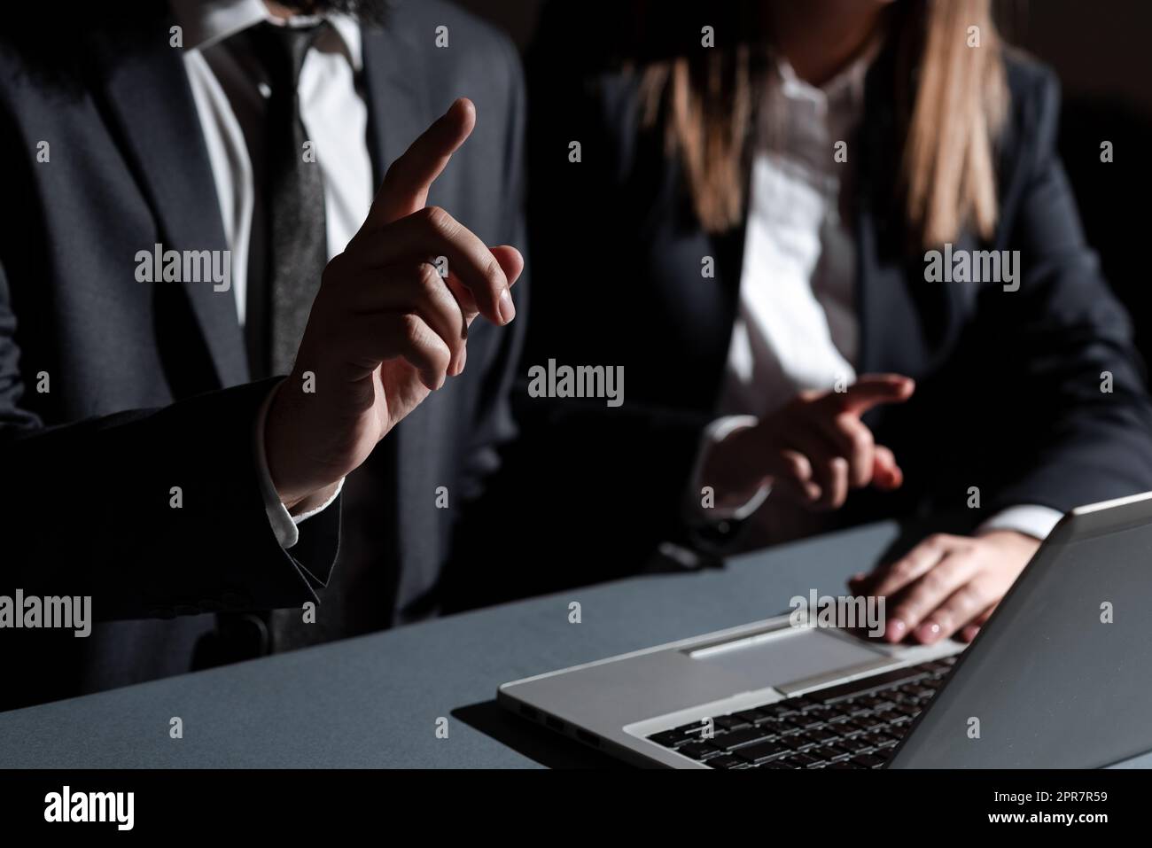 Homme et femme pointant avec les doigts sur les messages importants assis sur le bureau avec le recouvrement. L'équipe commerciale présente les informations les plus confidentielles avec les mains. Cadres montrant des données. Banque D'Images