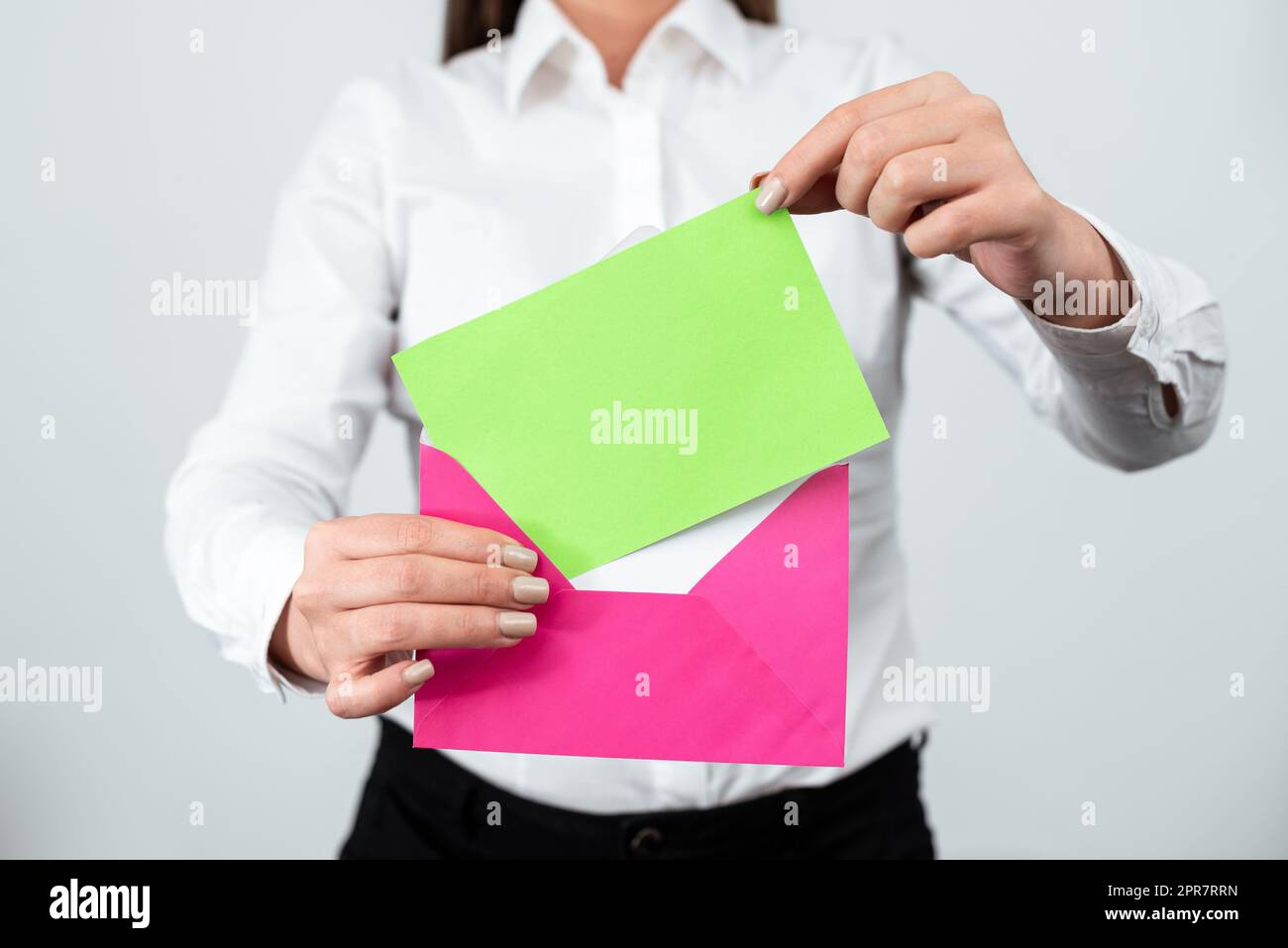 Élégante femme professionnelle debout et lettre de mise avec des informations importantes dans l'enveloppe. Femme d'affaires ayant la carte postale en mains envoyant un message crucial par courrier. Banque D'Images