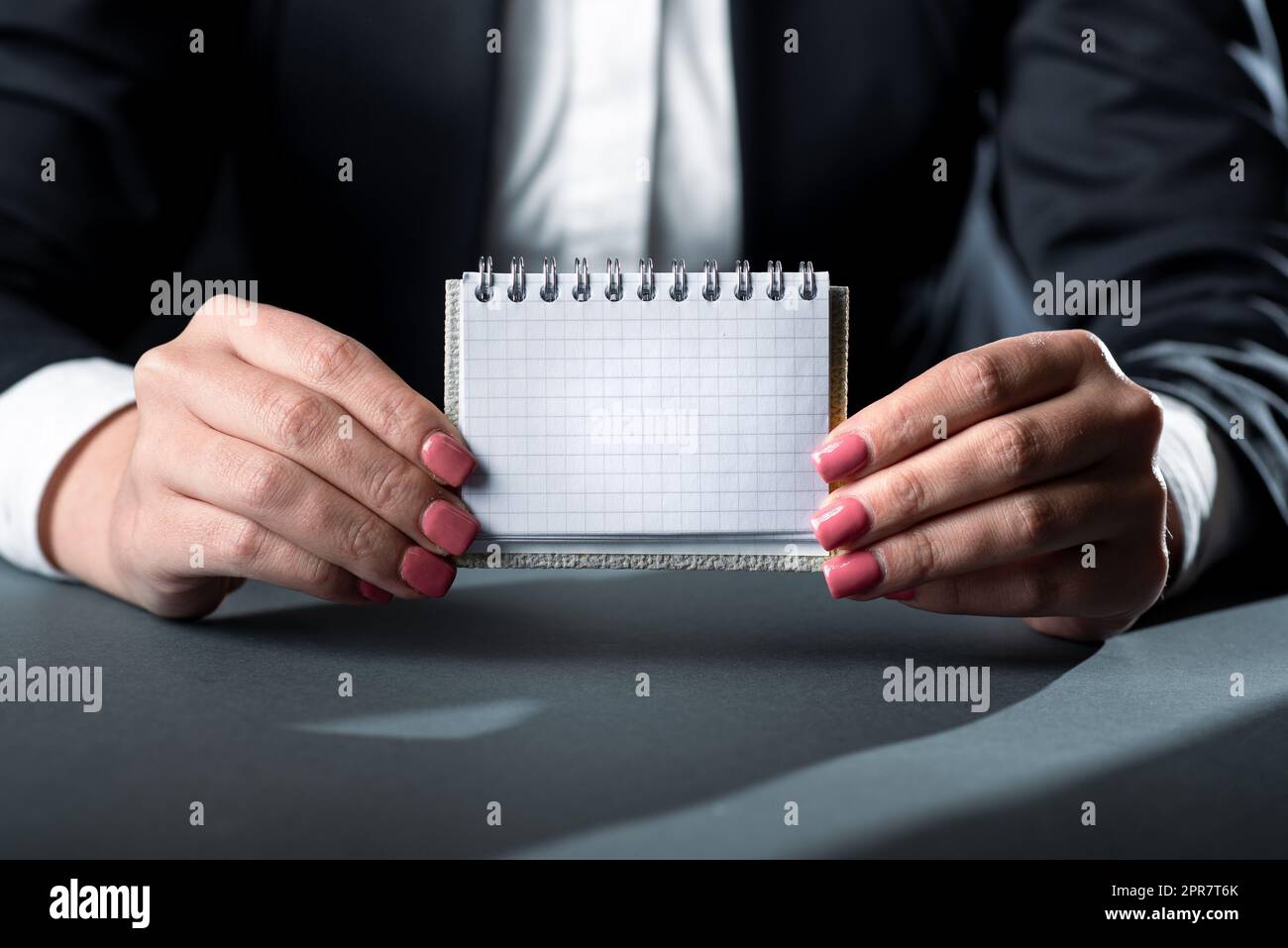 Femme d'affaires tenant une note avec un message important des deux mains. Femme ayant un petit ordinateur portable avec des informations de base entre les paumes. Directeur présentant des données critiques sur papier Banque D'Images