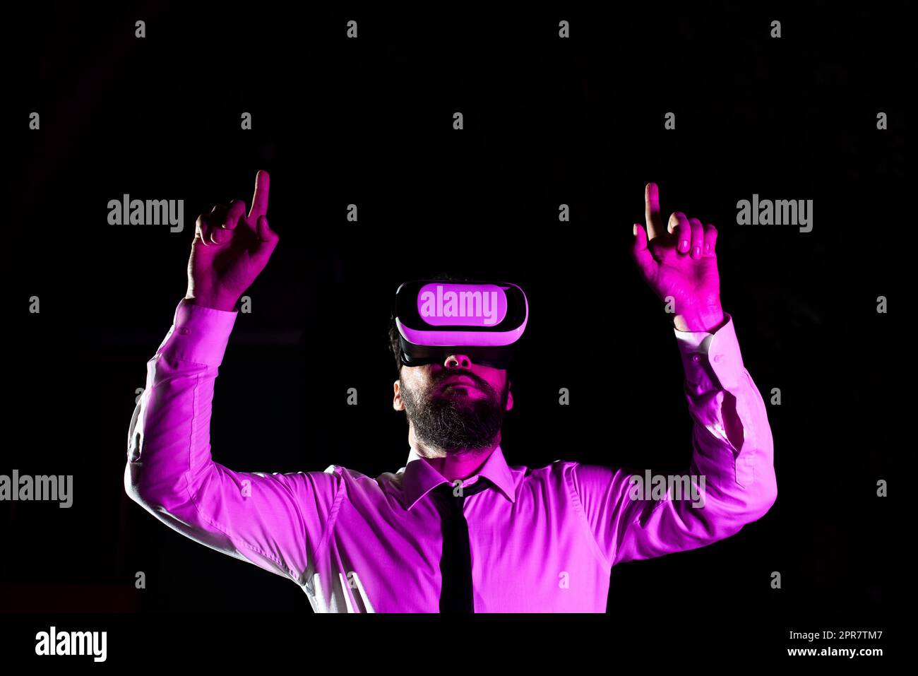Homme d'affaires utilisant des lunettes de réalité virtuelle gestant tout en suivant un entraînement professionnel. La lumière tombe sur l'homme qui fait l'expérience du simulateur et présente la technologie moderne. Banque D'Images