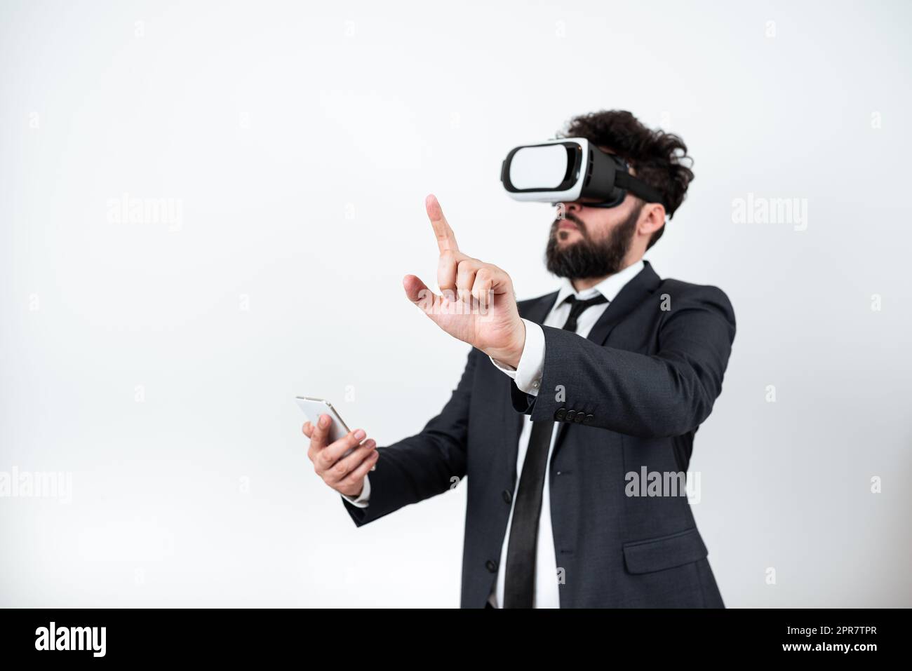 Homme portant des lunettes VR et pointant d'un doigt sur des messages importants. Homme d'affaires ayant des lunettes de réalité virtuelle et montrant des informations crutiales. Banque D'Images