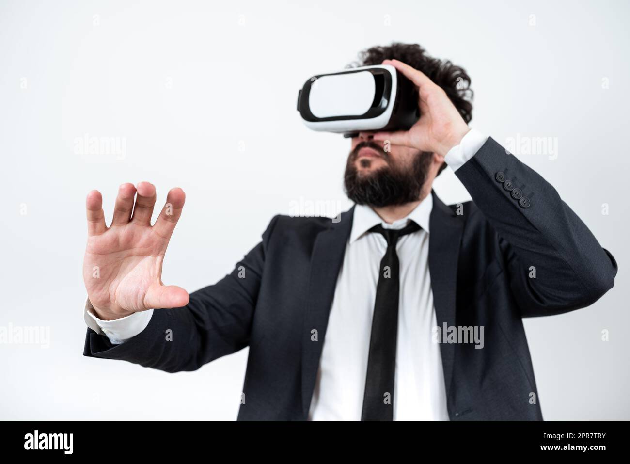 Homme portant des lunettes VR et présentant des messages importants d'une main. Homme d'affaires ayant des lunettes de réalité virtuelle et montrant des informations crutiales. Banque D'Images
