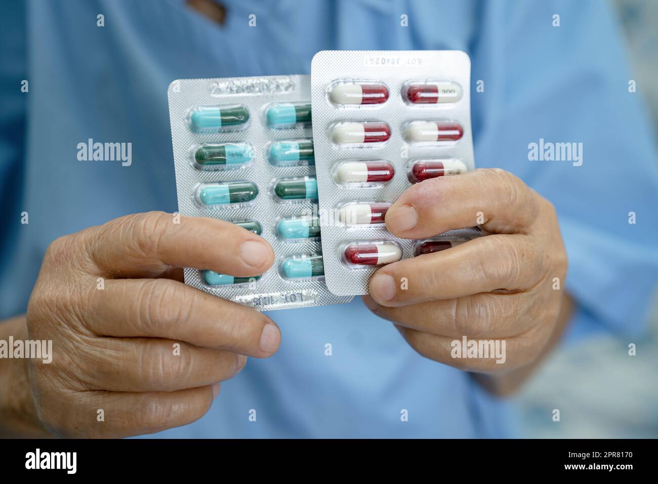 Asiatique senior ou âgée vieille femme patiente tenant des antibiotiques capsule pilules dans l'emballage blister pour le traitement infection patient à l'hôpital, pharmacie concept de pharmacie. Pharmacie concept pharmacie. Banque D'Images