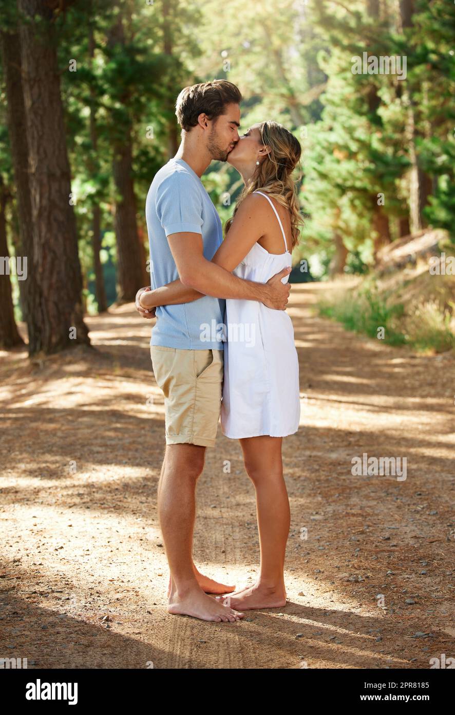 Je t'aime et j'aime l'exprimer. Photo d'un jeune couple partageant un baiser tout en explorant le plein air. Banque D'Images