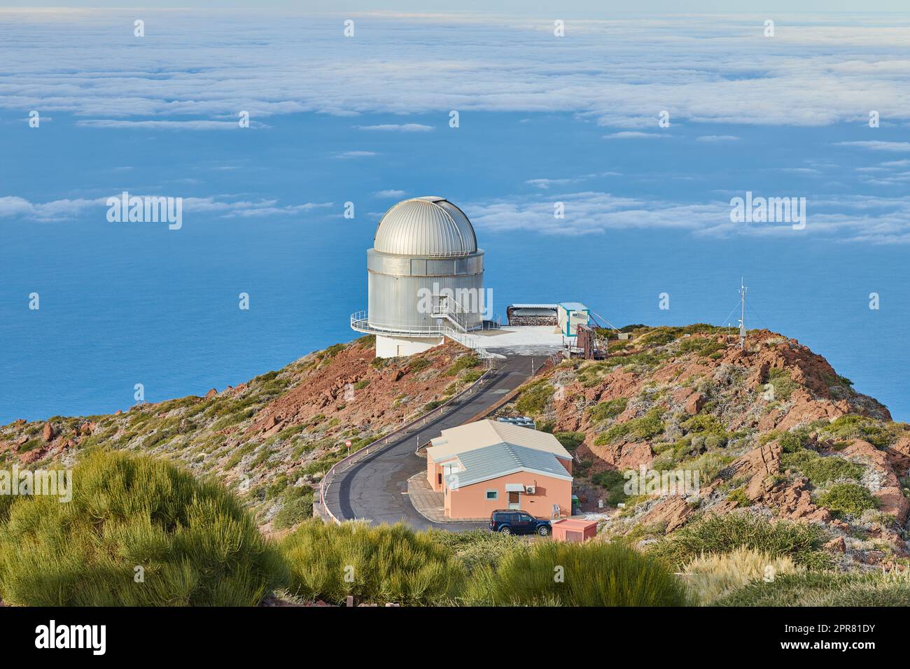 Observatoire Roque de los Muchachos à la Palma. Une route vers un observatoire astronomique avec ciel bleu et espace de copie. Télescope entouré de verdure et situé sur une île au bord d'une falaise. Banque D'Images