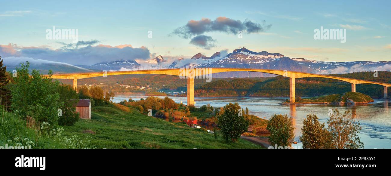 Vue sur le paysage de Saltsaumen dans le Nordland, Norvège en hiver. Paysage d'infrastructure et de pont sur une rivière et un ruisseau avec des montagnes enneigées en arrière-plan. Voyager à l'étranger et à l'étranger Banque D'Images