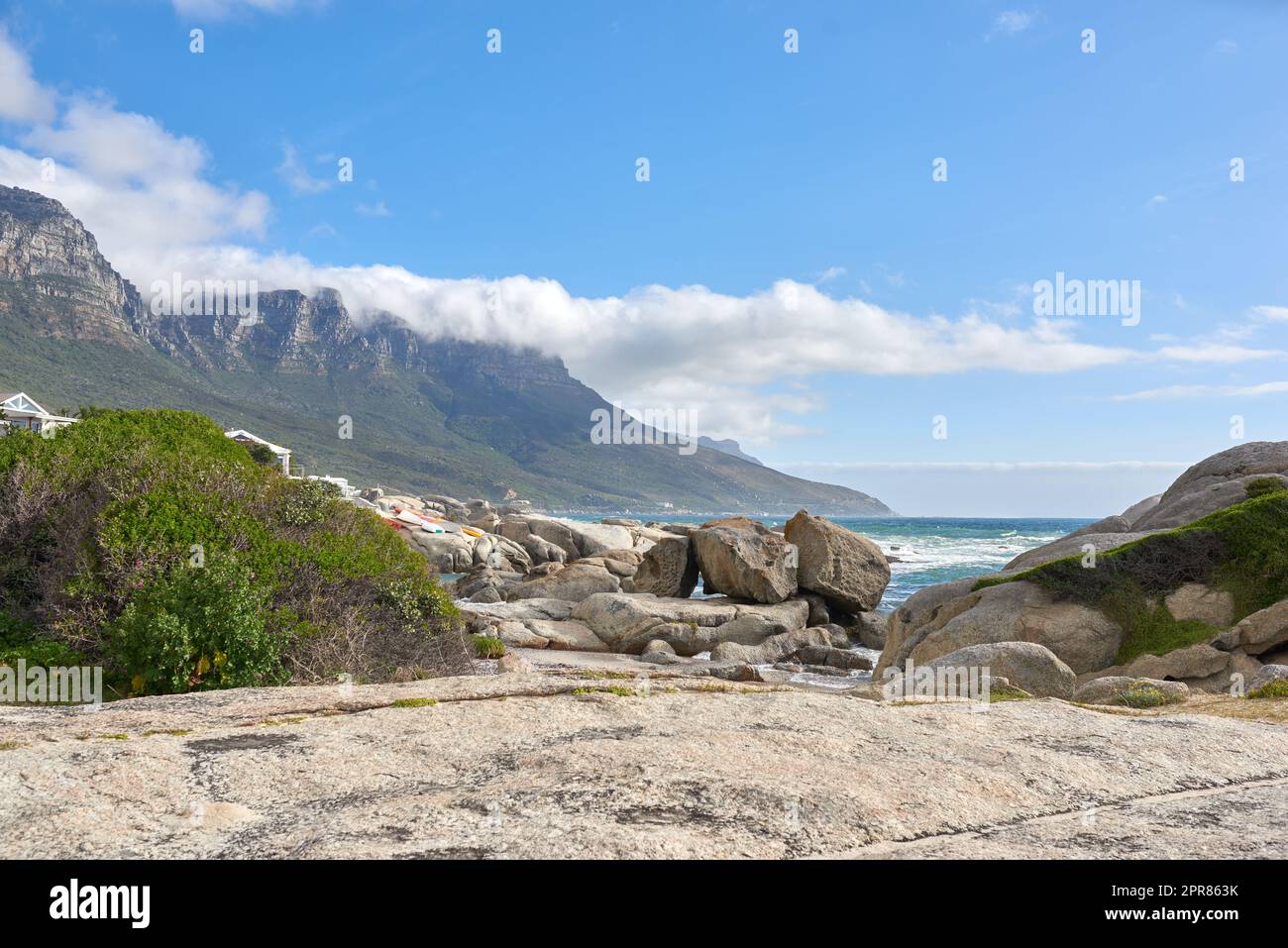 Magnifique paysage de camps Bay au Cap, Afrique du Sud. Montagnes pittoresques et rochers près de l'océan ou de la mer avec un fond bleu ciel. Nature paisible à la plage avec paysage marin pendant une journée d'été Banque D'Images